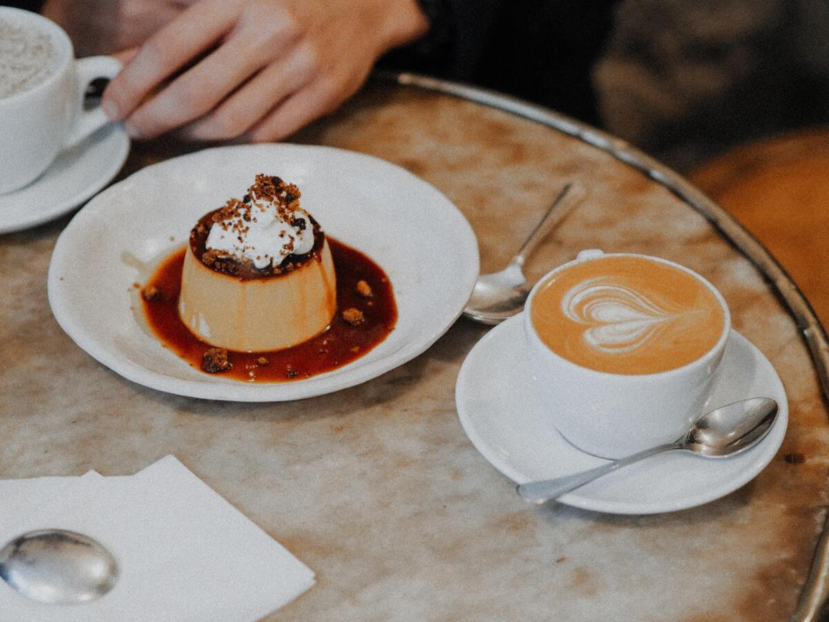 Prato de pudim e xícara de café em uma mesa. 