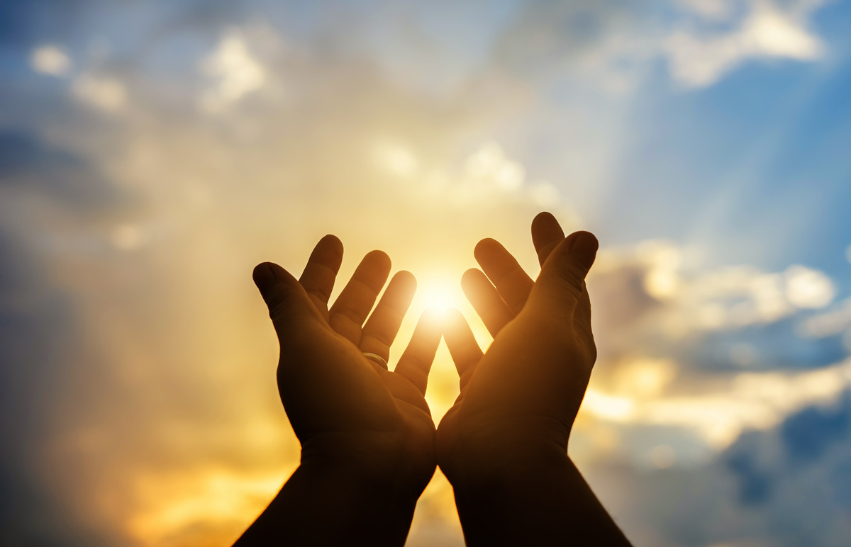 Mãos se levantando em direção ao Sol