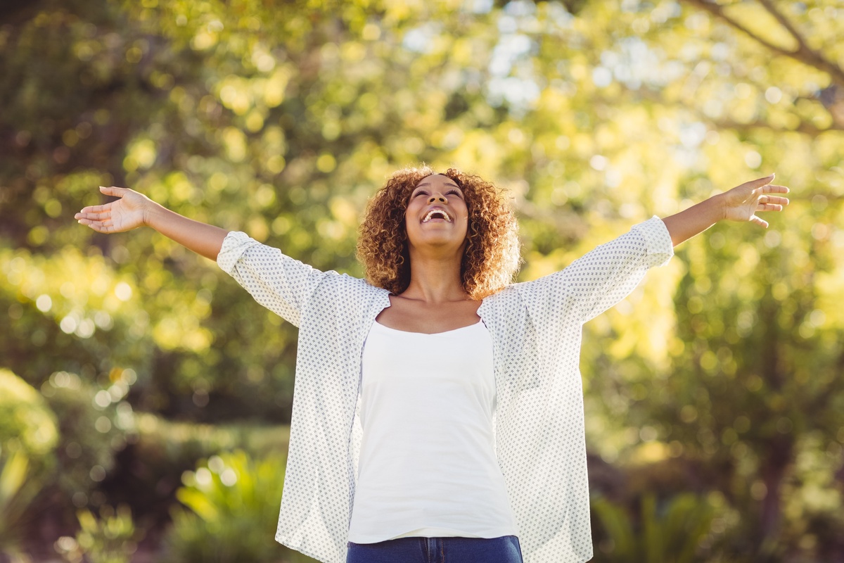 Mulher feliz em lugar no qual sonhou várias vezes