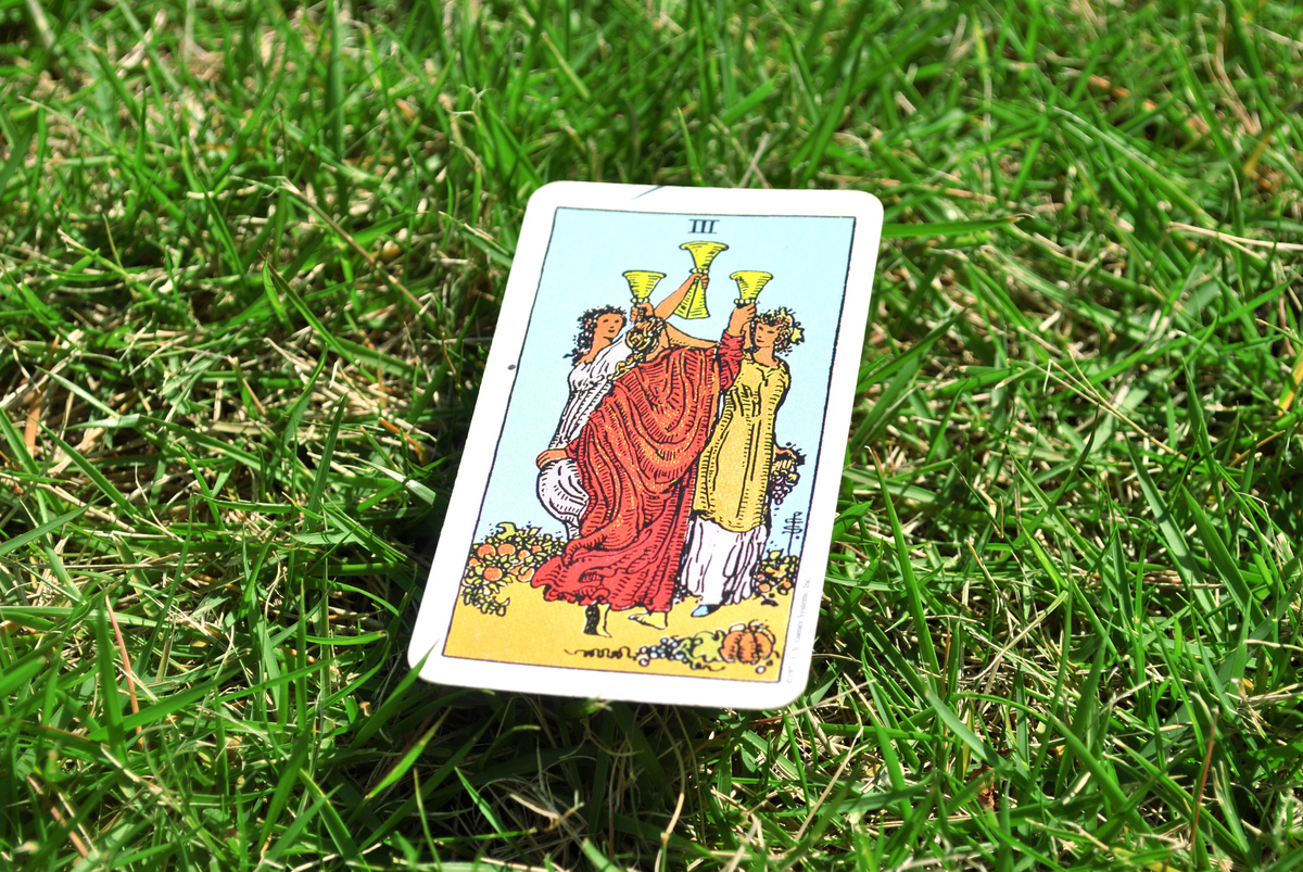 carta de tarot 3 de copas na grama verde