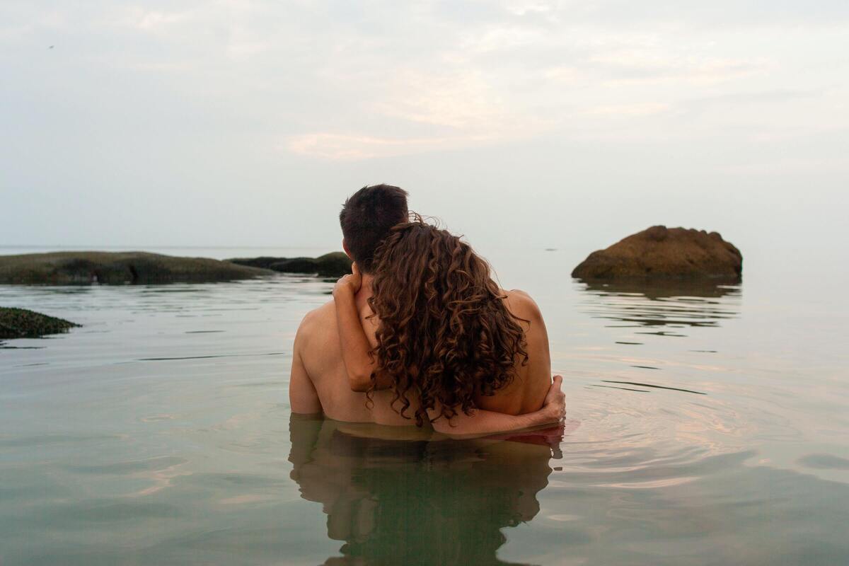 Casal abraçado no mar.