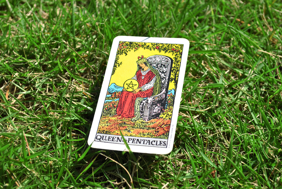 Carta de Rainha de Ouros no Tarot na grama