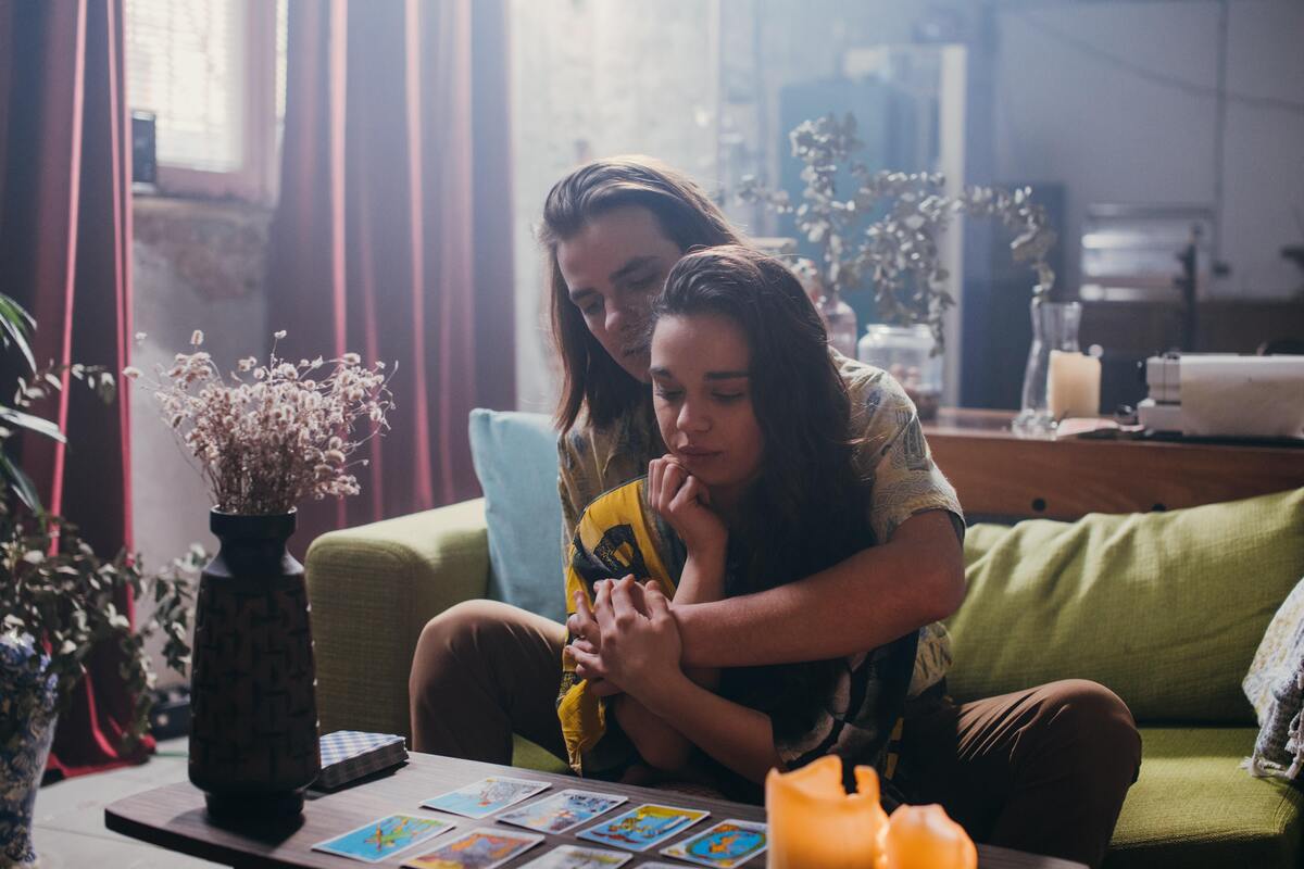 Casal abraçado lendo cartas de tarot