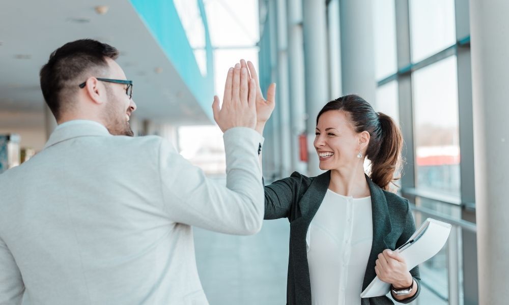 colegas de trabalho dando as mãos comemorando