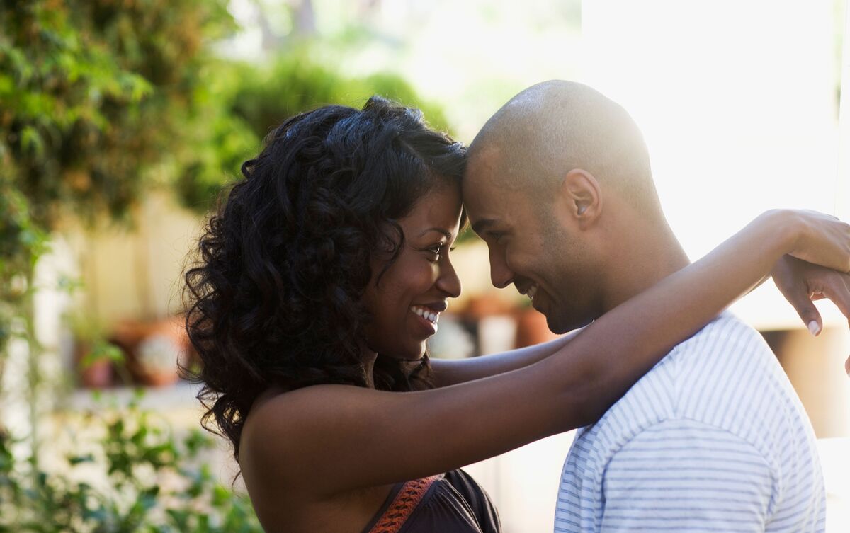 Casal de homem e mulher abraçados e sorrindo.