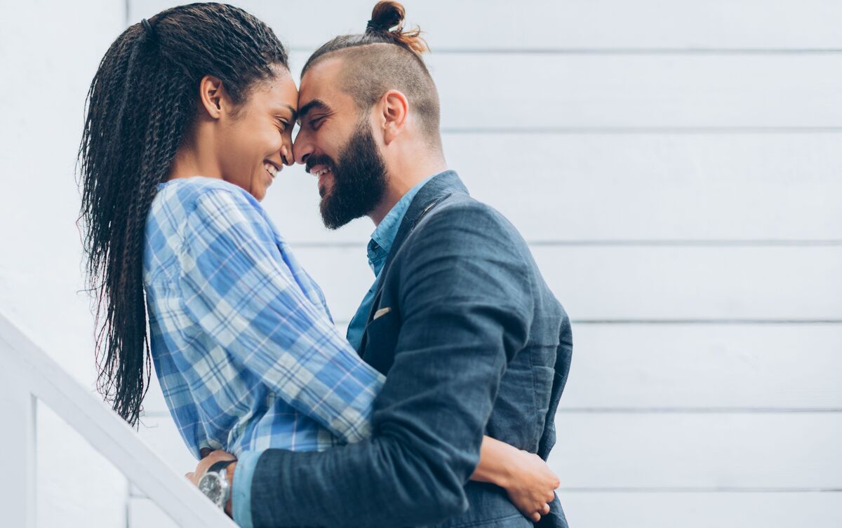 Casal de mulher e homem abraçados.