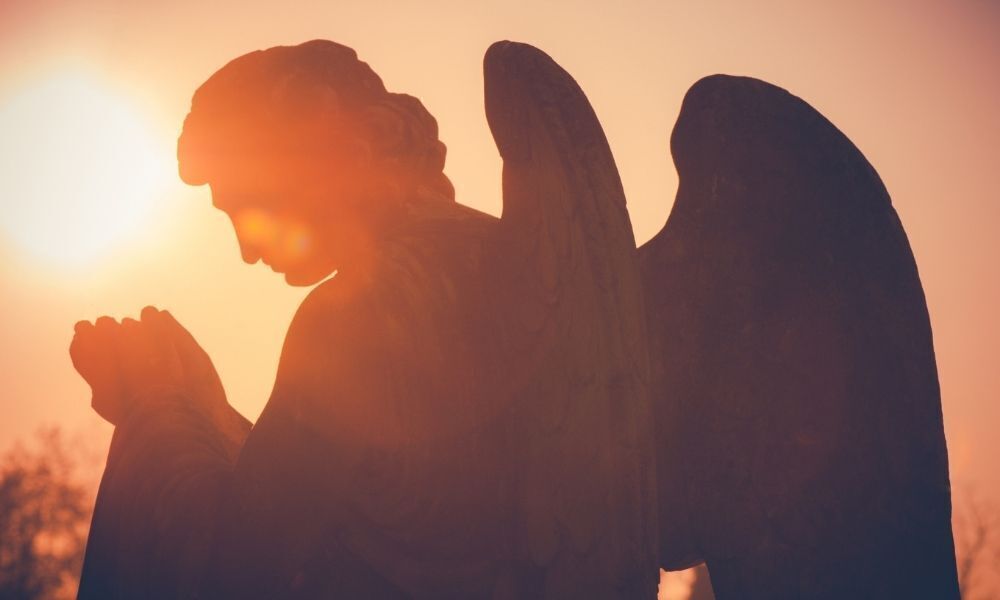 ANJO DE MÃOS POSTAS NO POR DO SOL