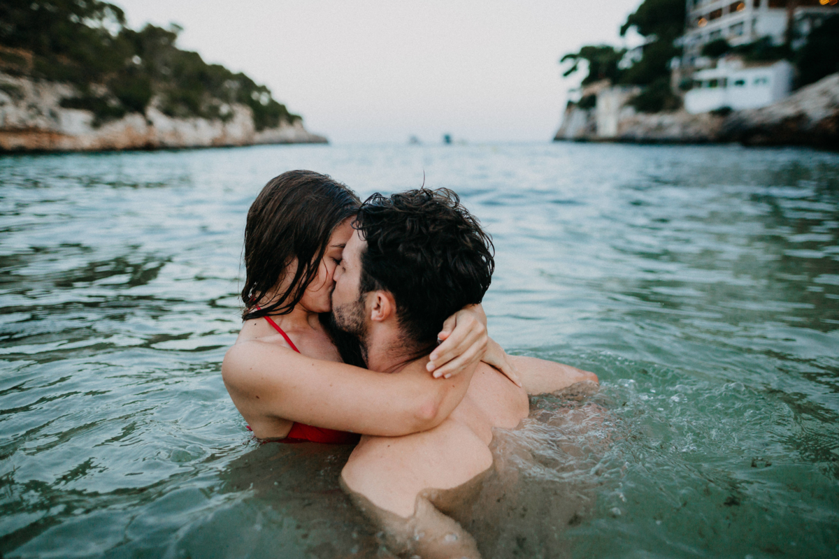 Casal se beijando no mar.