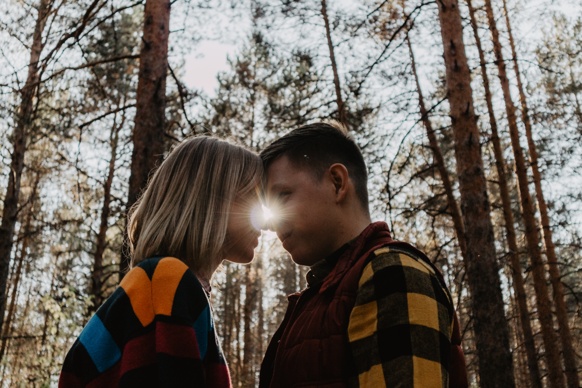 Casal se encarando em uma floresta. 