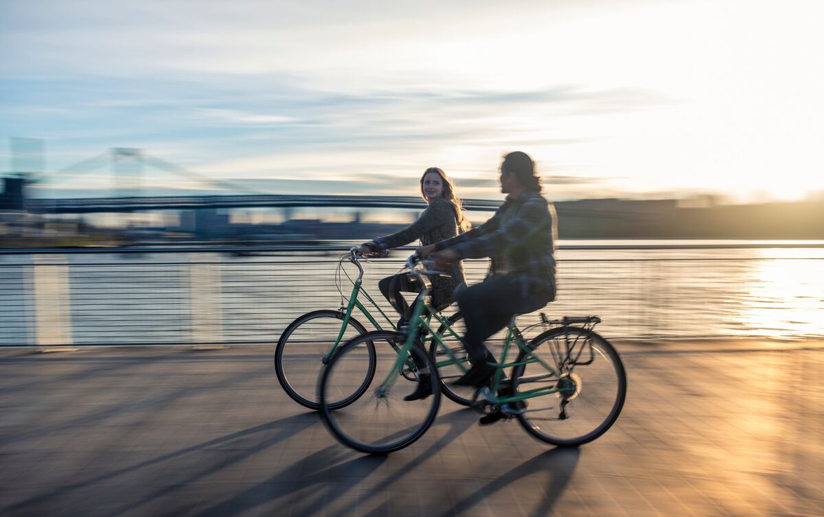 Casal de homem e mulher andando de bicicleta em encontro.