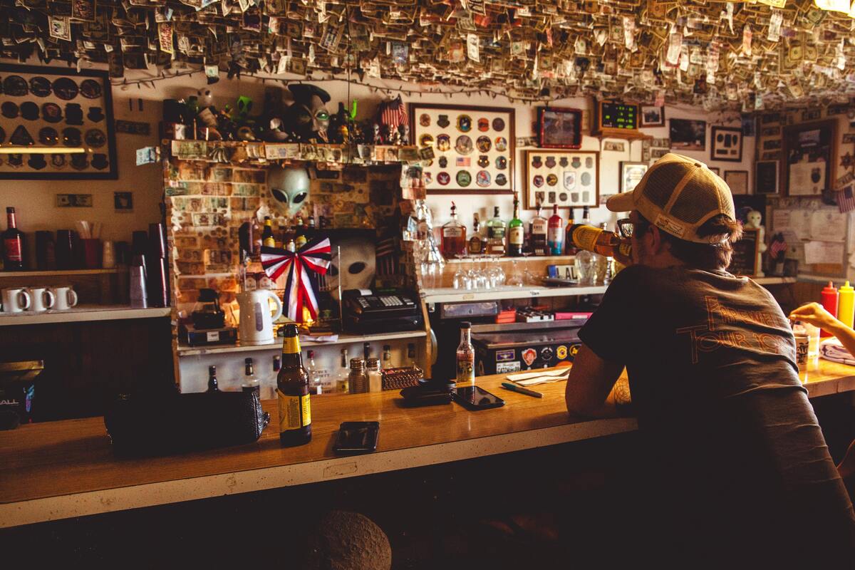 Homem bebendo sozinho em um bar.