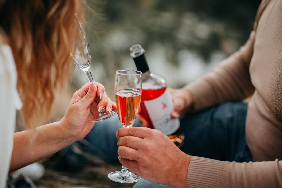 Um homem servindo uma taça de vinho Rosé para uma mulher