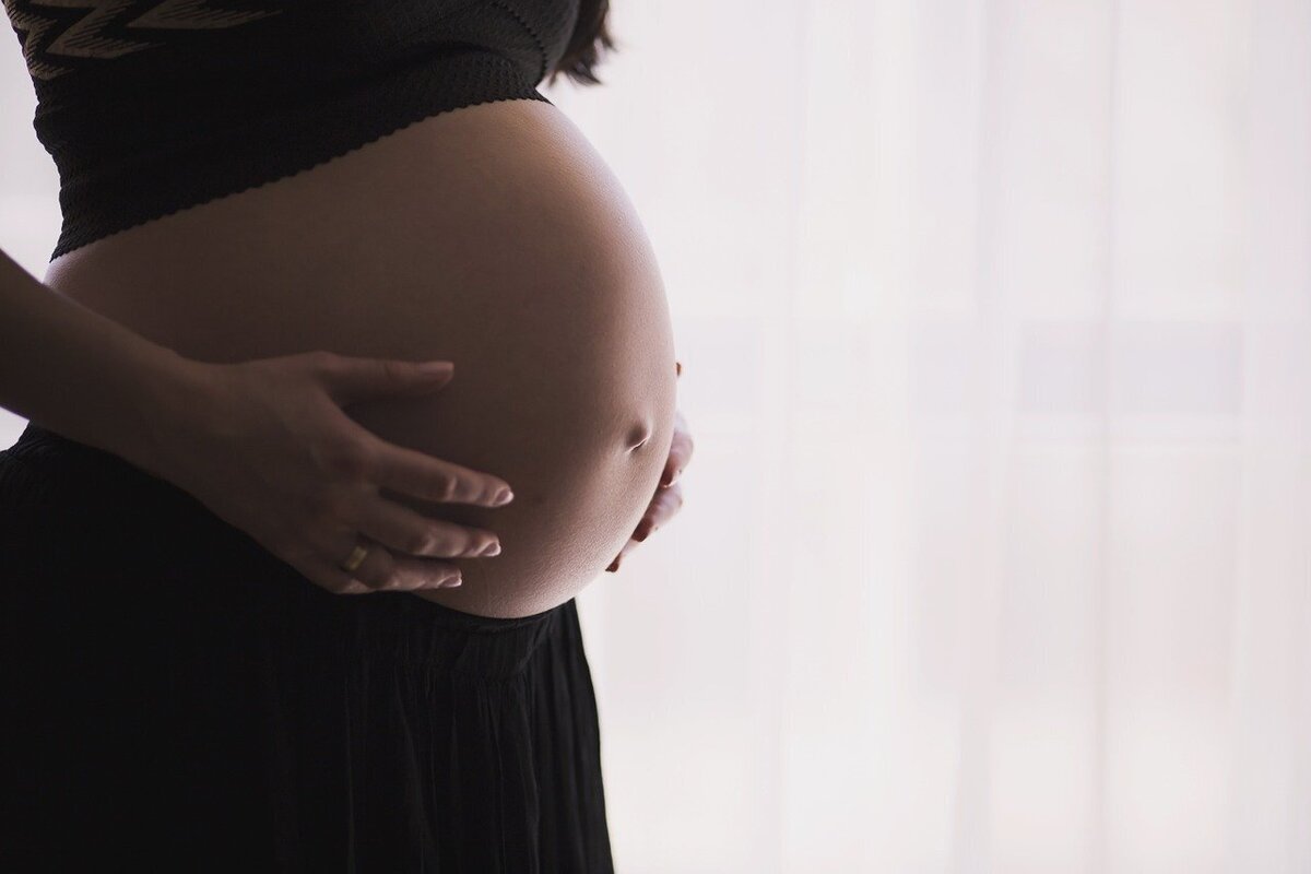 Grávida passando a mão da barriga