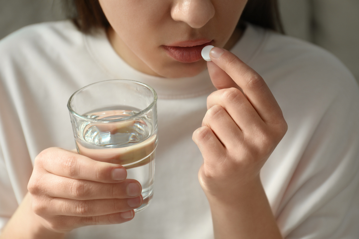 Mulher tomando remédio para abortar