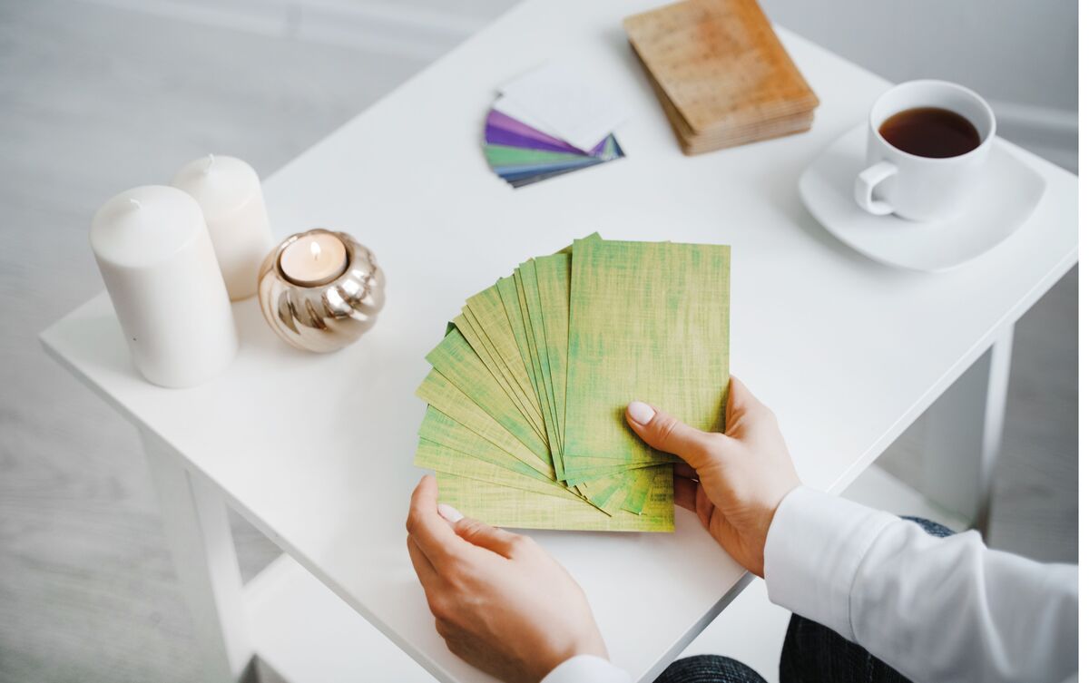 Pessoa segurando deck de cartas de Tarot.