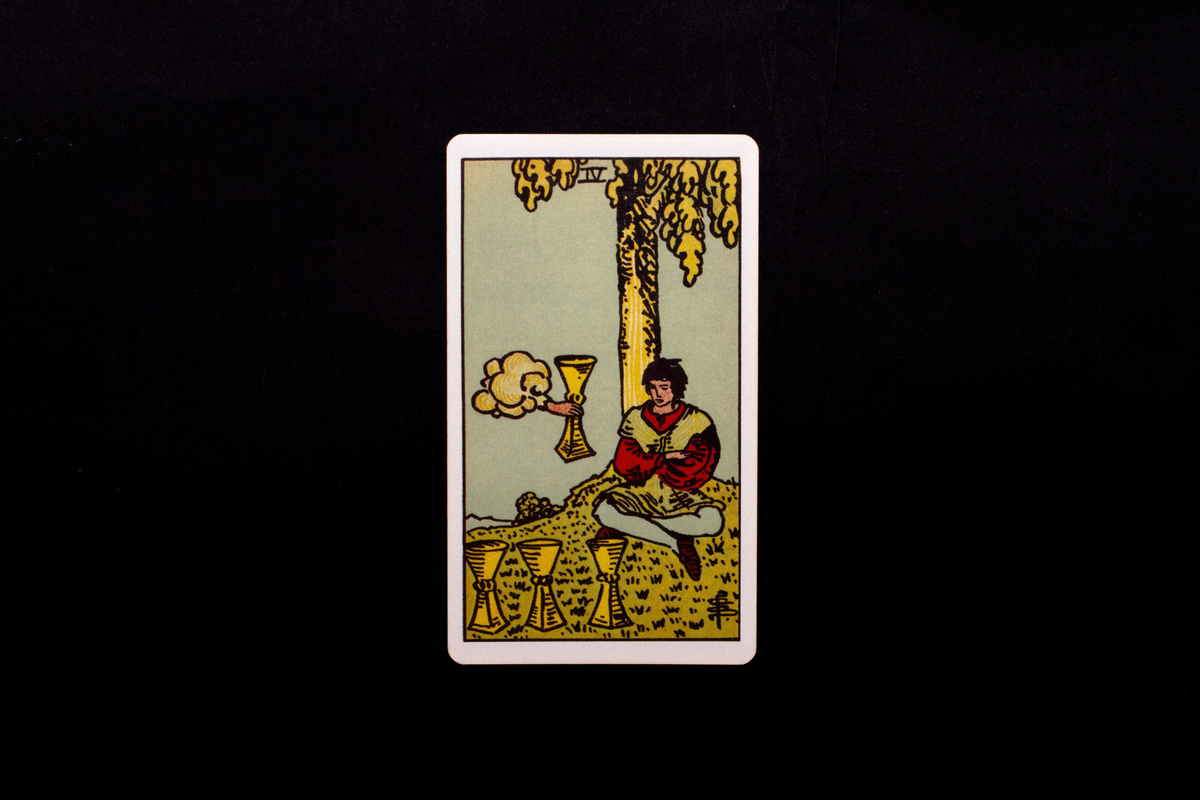 Cartas 4 de Copas do Tarot em fundo preto.