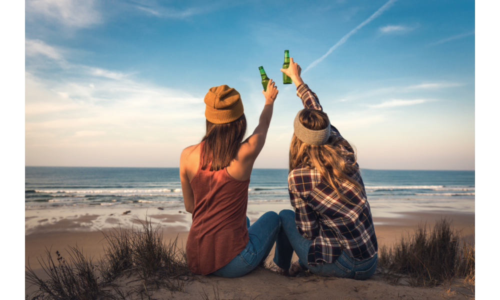 Amigas de Áries e Câncer fazendo um brinde na praia