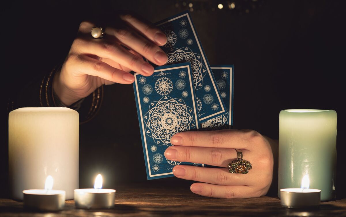 Pessoa segurando cartas de Tarot nas mãos.