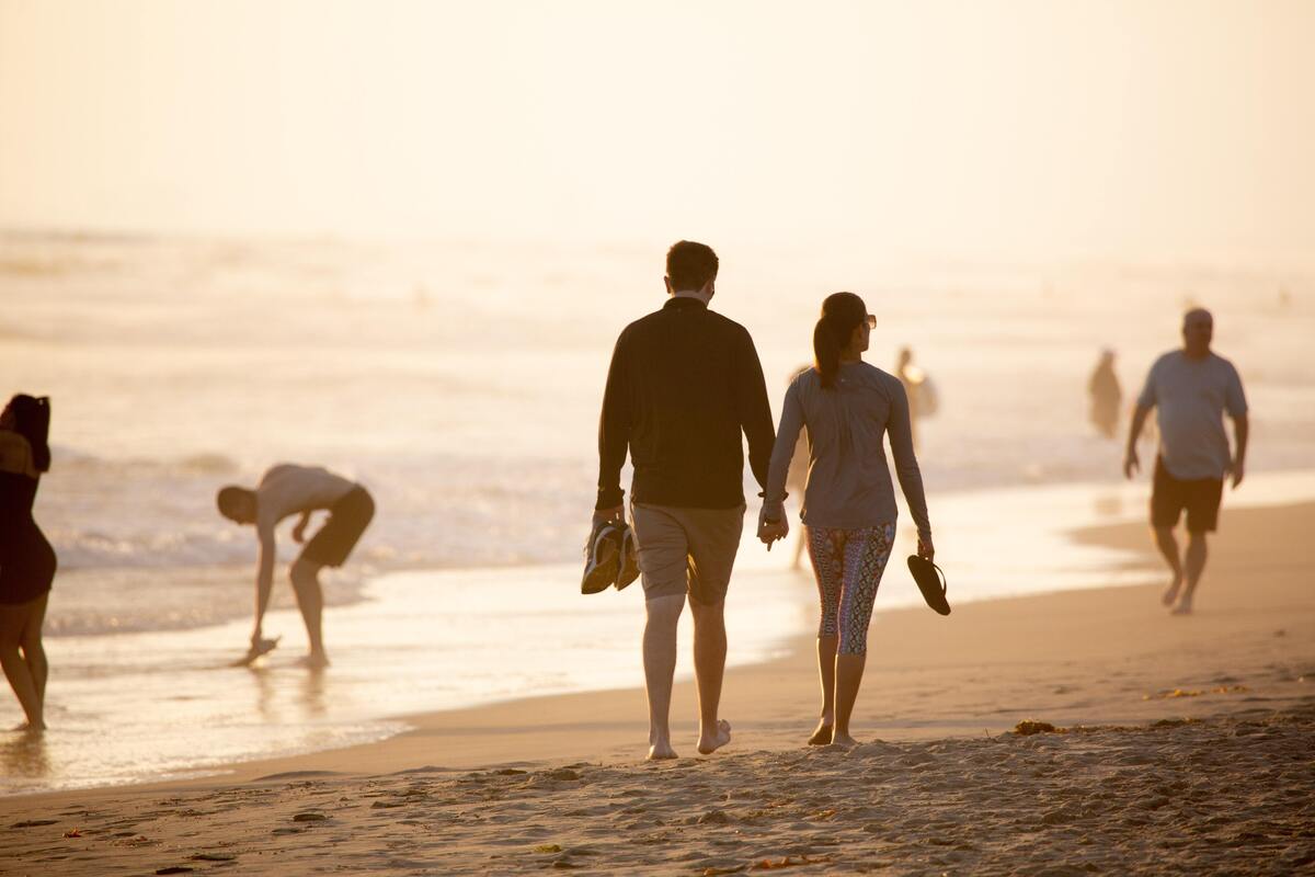 Casal de mãos dadas na praia. 