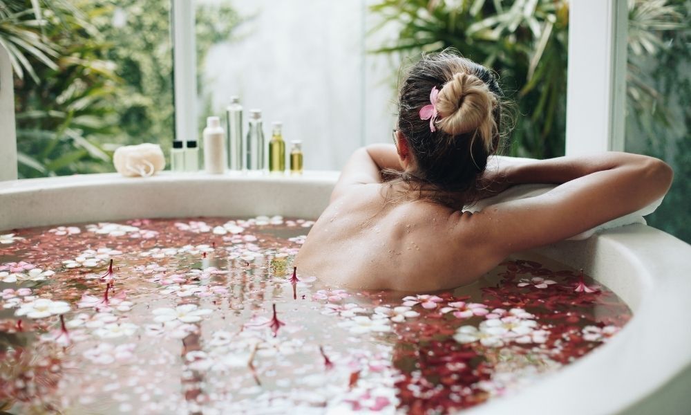 mulher tomando banho de ervas e flores