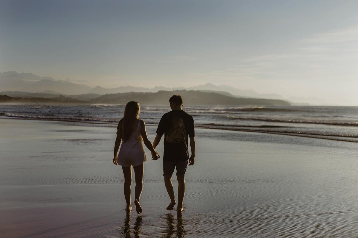 Casal de mãos dadas na praia. 