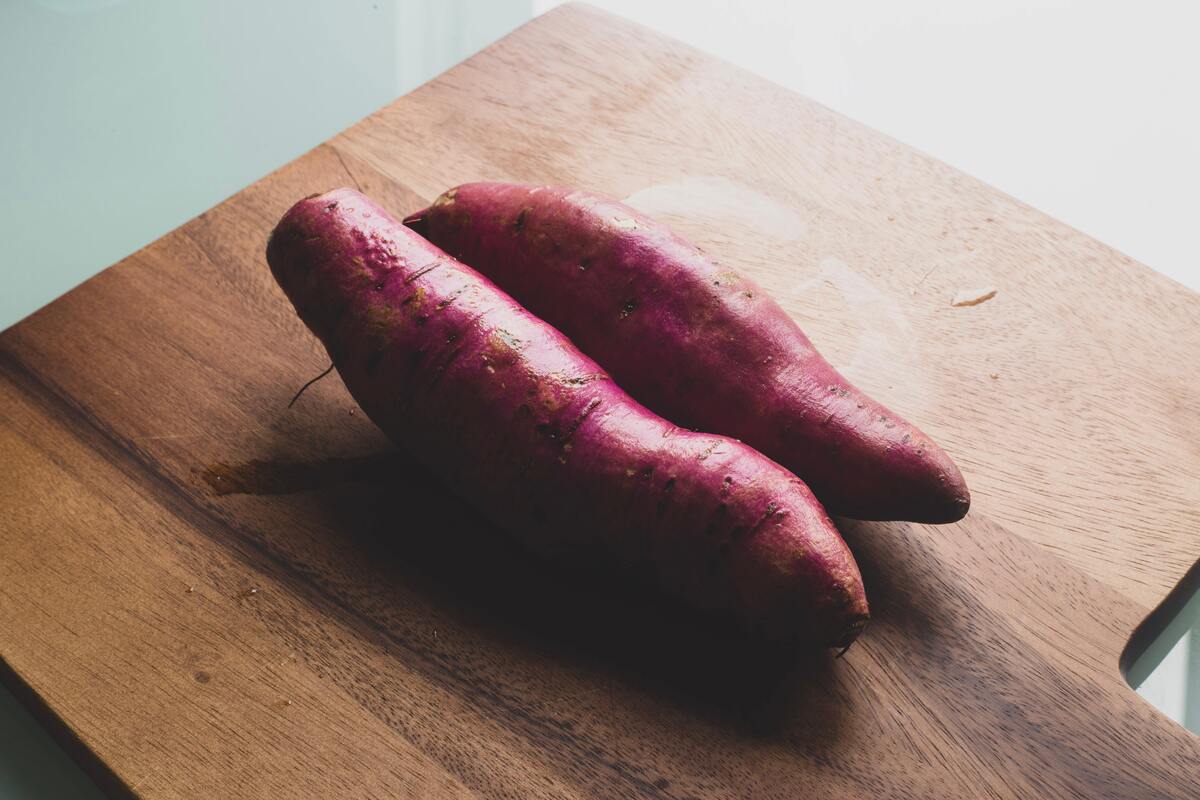 Batata doce roxa em tábua de madeira