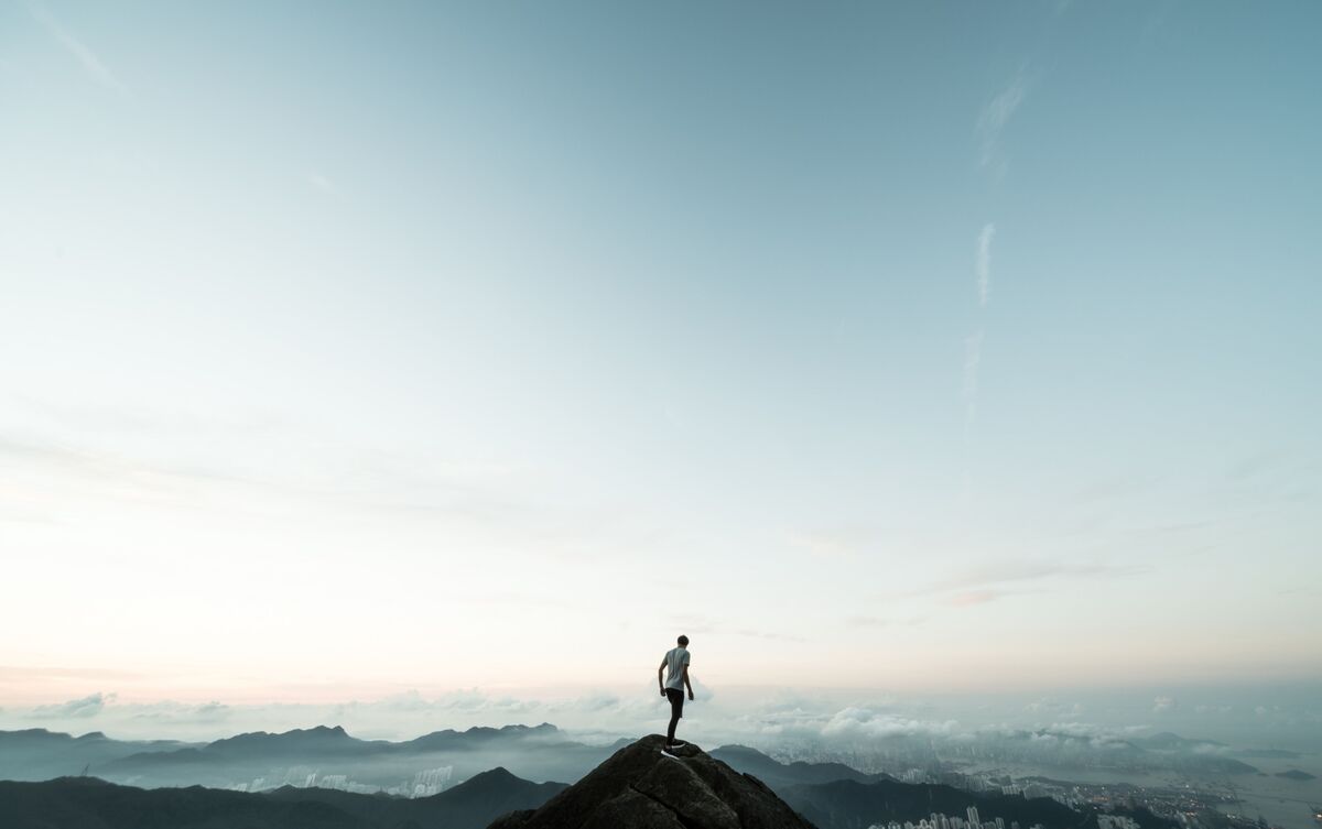 Homem no topo de montanha nas nuvens.