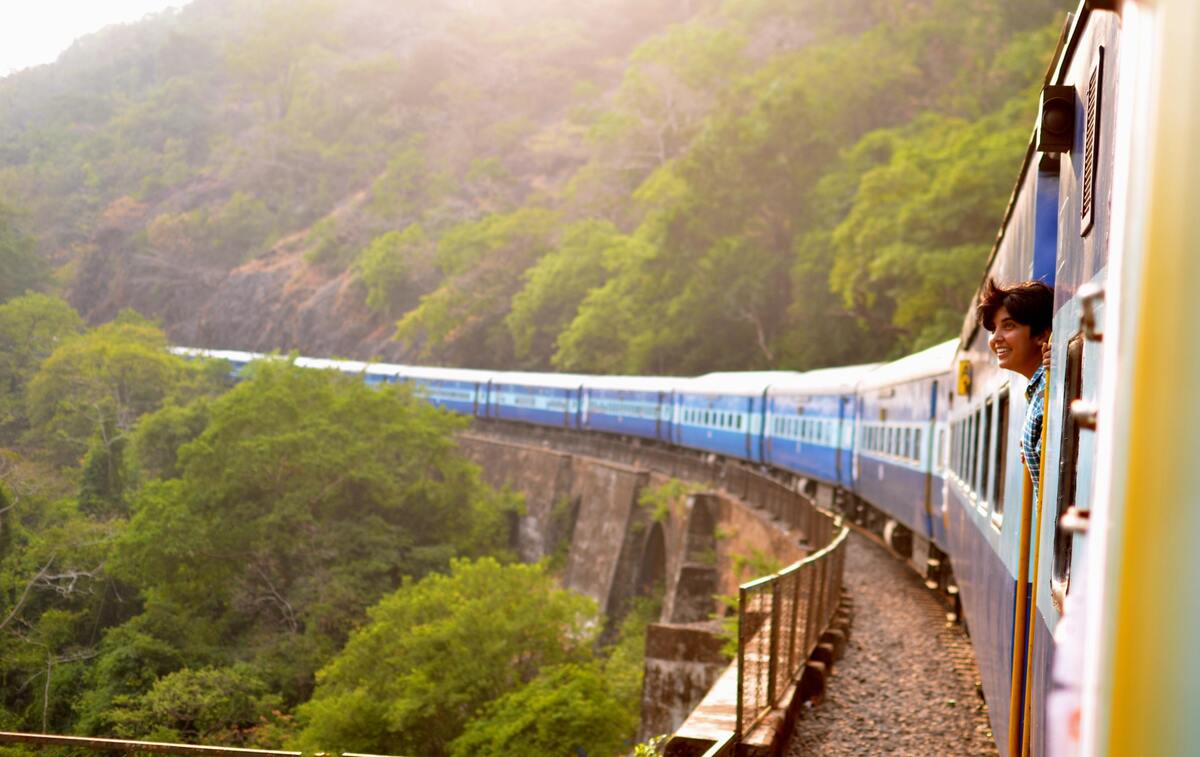 Mulher olhando para uma paisagem de dentro de um trem.