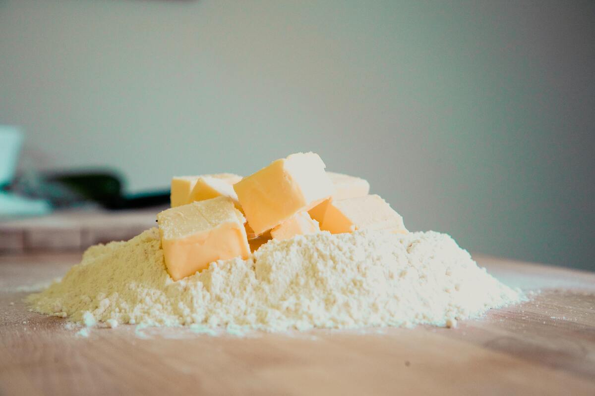 Uma mesa com farinha e cubos de manteiga