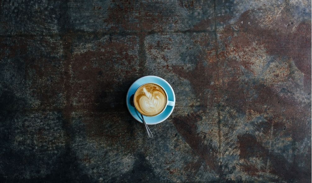 Xícara de café azul em fundo escuro