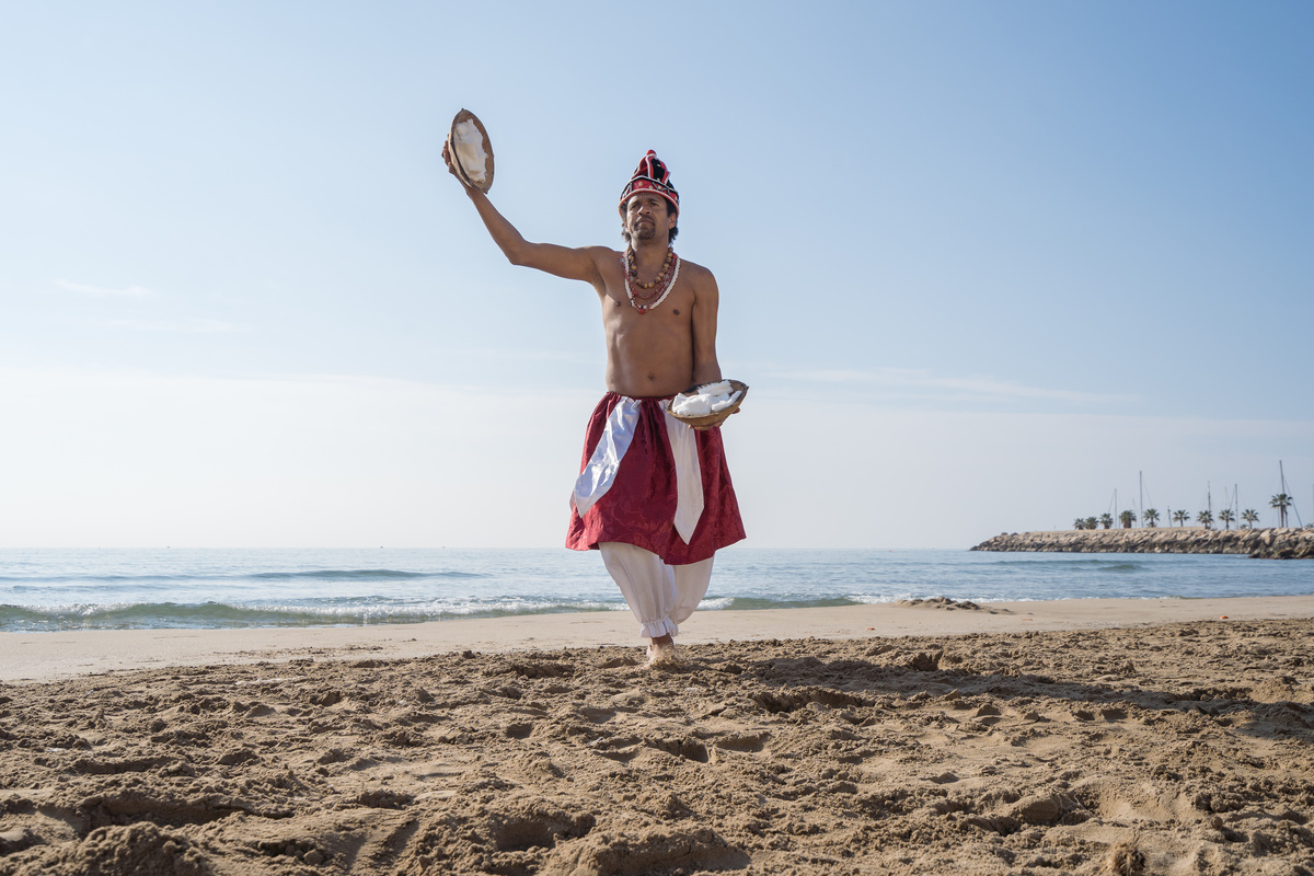 Homem na praia vestido de Orixá Xangô