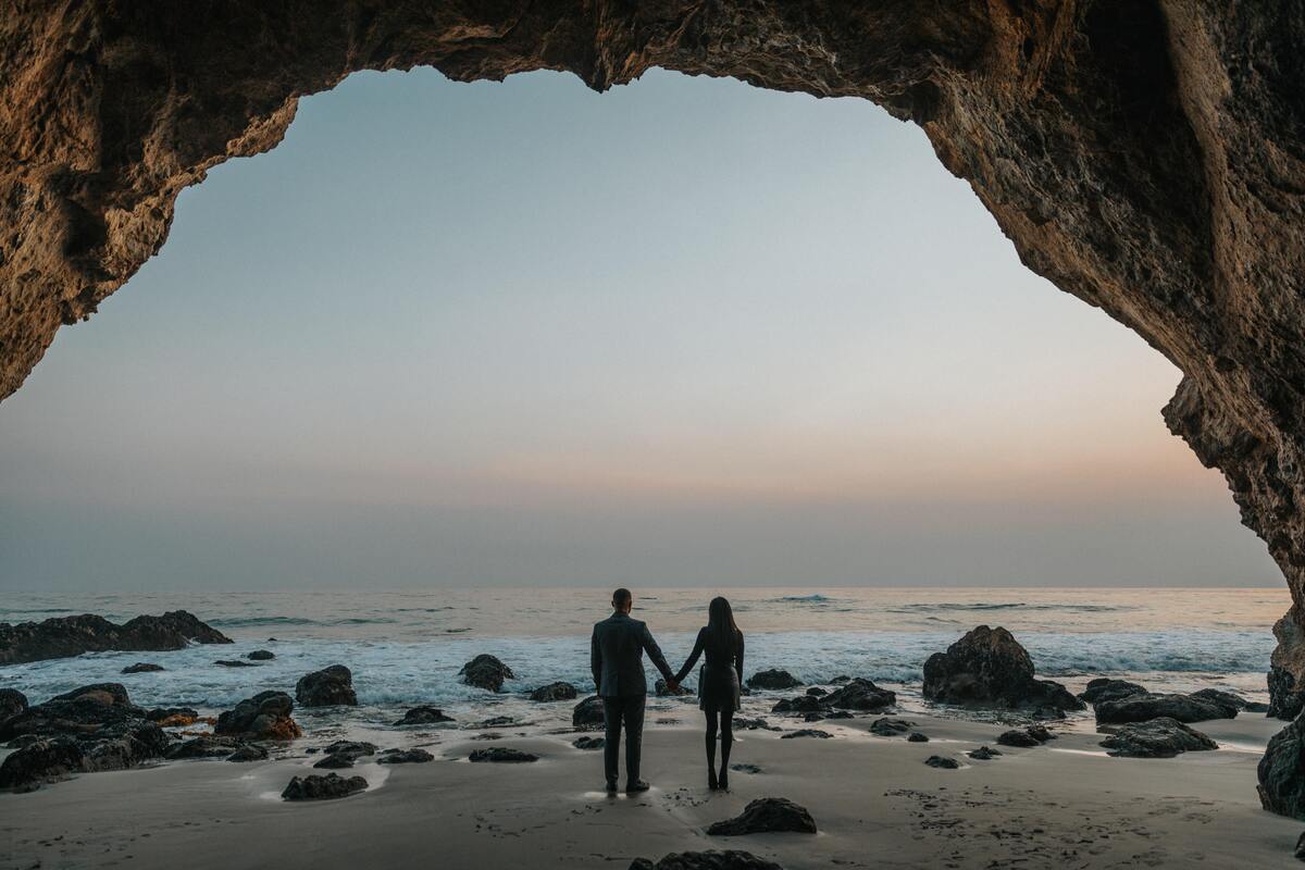 Casal de mãos dadas na praia. 