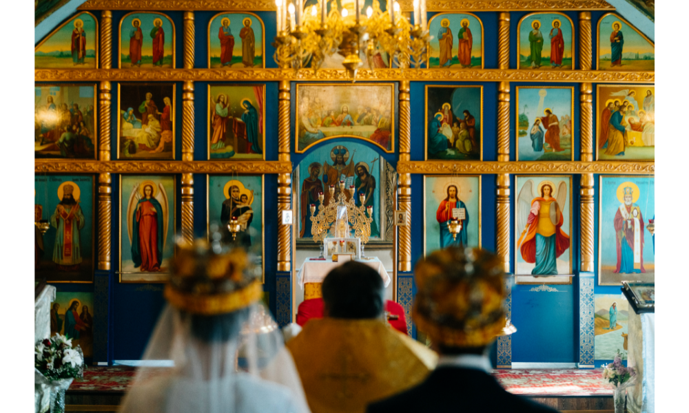 Pessoas olhando para imagens religiosas em uma igreja.