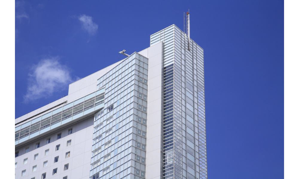 Edifício branco alto, céu ao fundo.