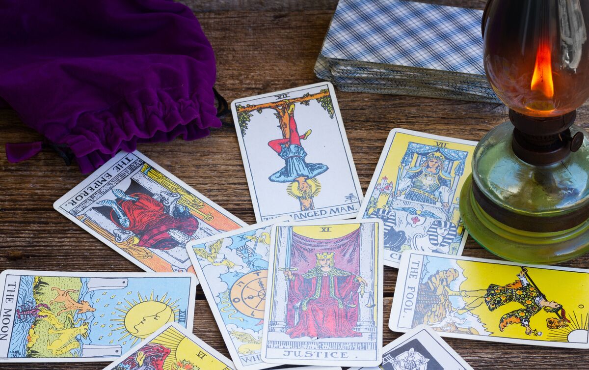 Carta O Enforcado do Tarot em meio a outros Arcanos.