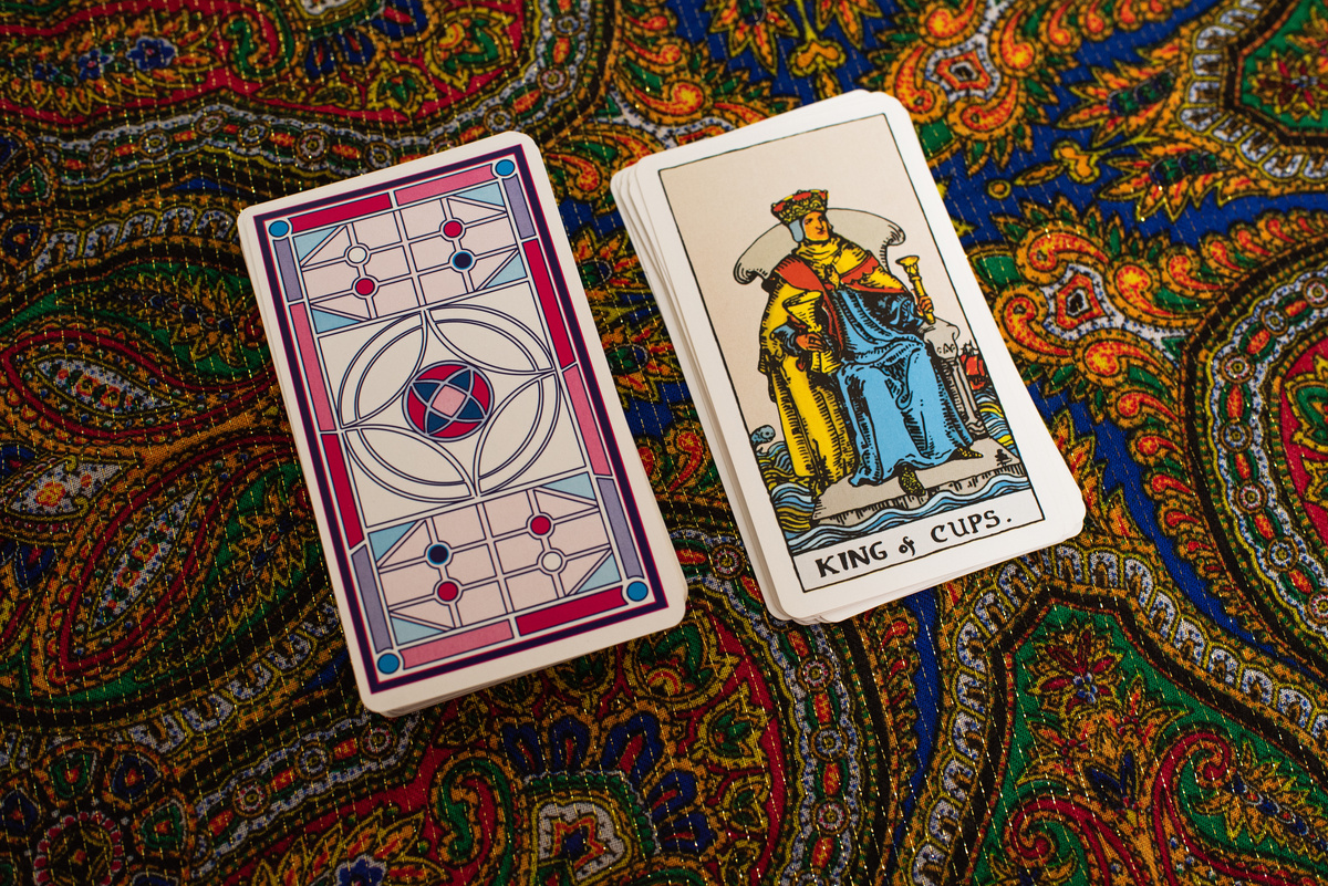 Carta "king of cups" (rei de ouros) em fundo de tapeçaria