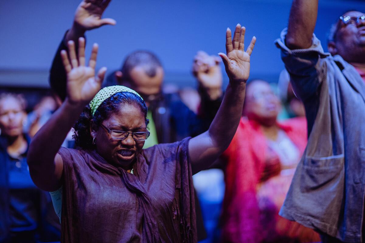 Várias pessoas rezando em culto