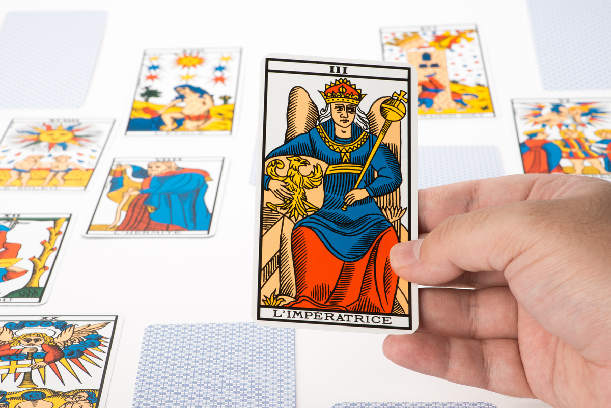 Pessoa segurando a carta Imperatriz após tiragem de tarot