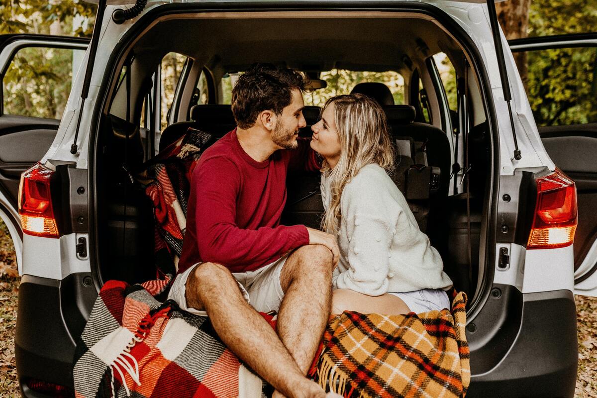 Casal dentro da parte traseira de uma van. 