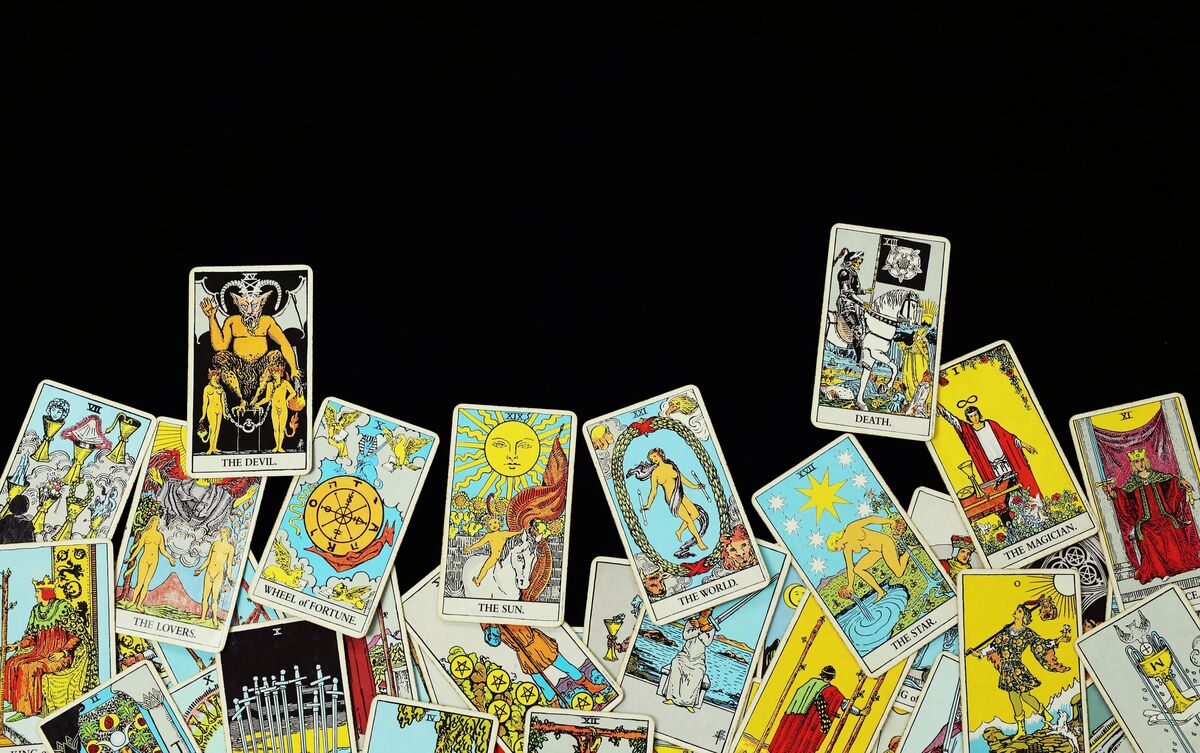 Cartas de Tarot embaralhadas em fundo preto.