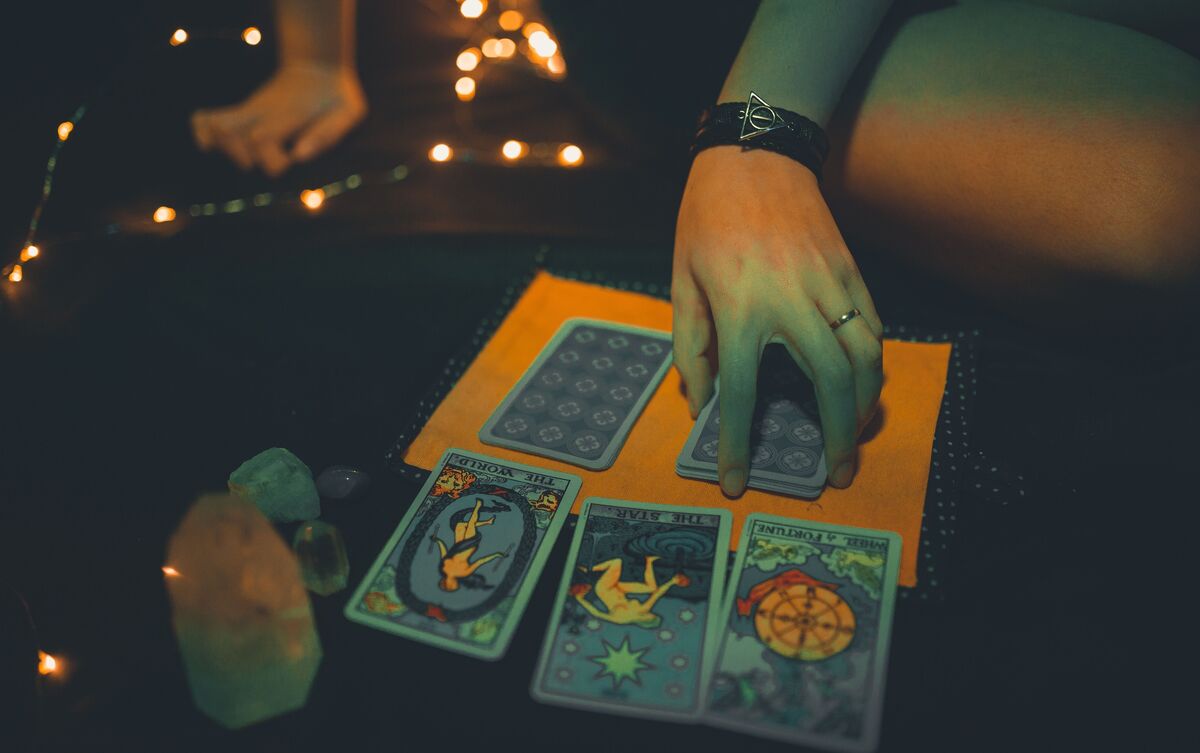 Cartas de Tarot enfileiradas sobre mesa.