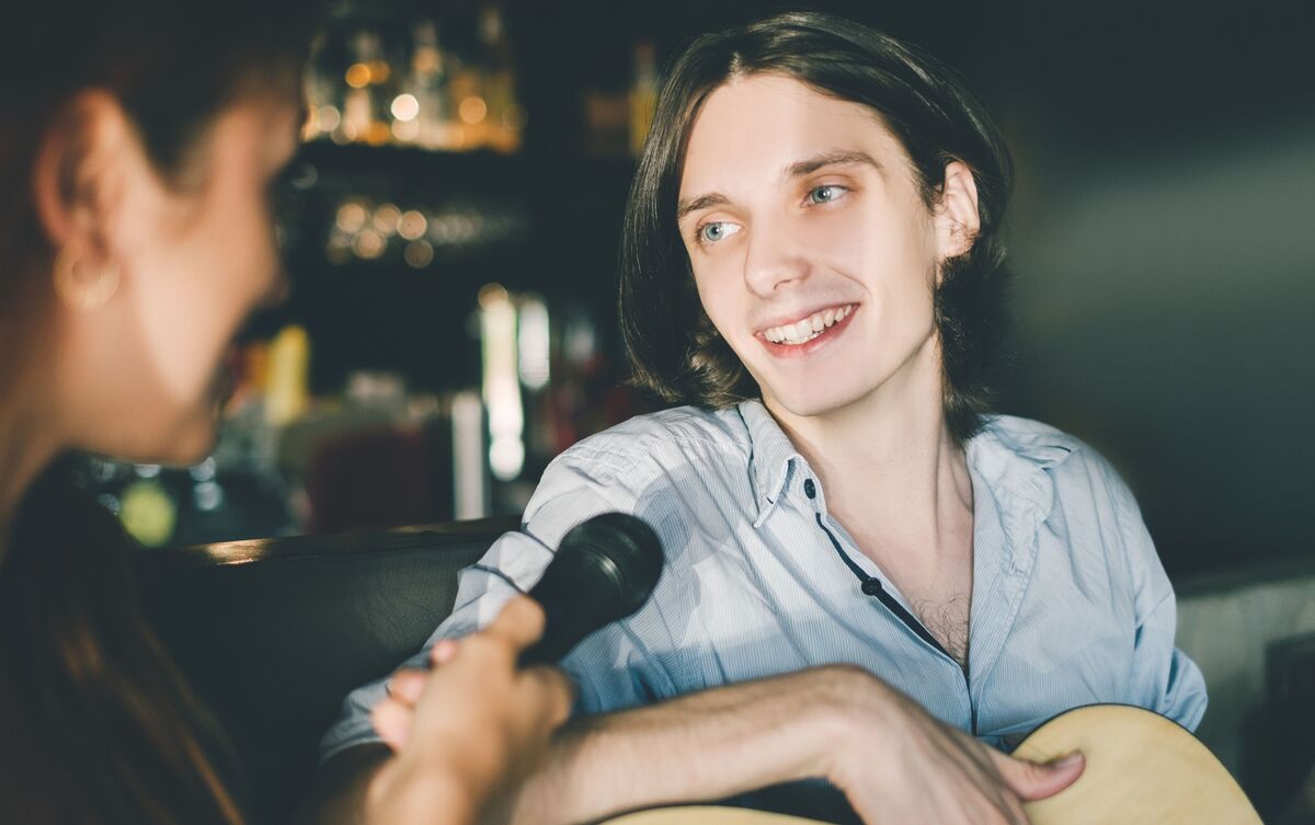 Cantor famoso sendo entrevistado por mulher.