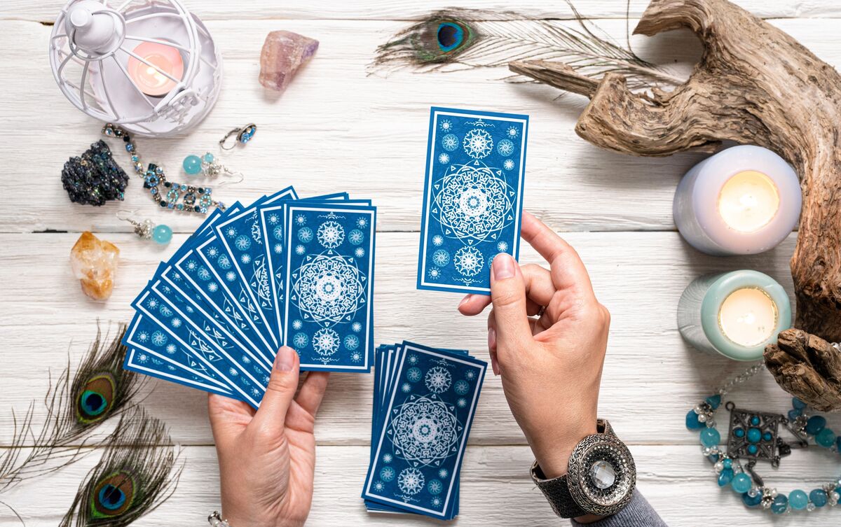 Cartas de Tarot sendo tiradas por taróloga.