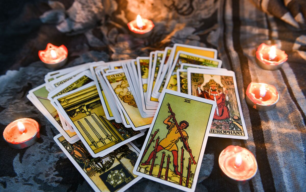 Cartas de Tarot embaralhadas sobre mesa.