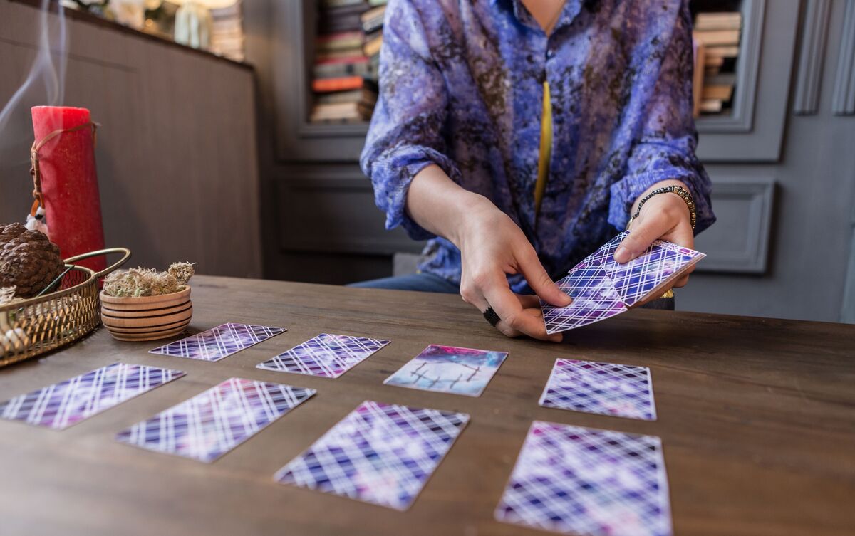 Cartas de Tarot enfileiradas sobre mesa.