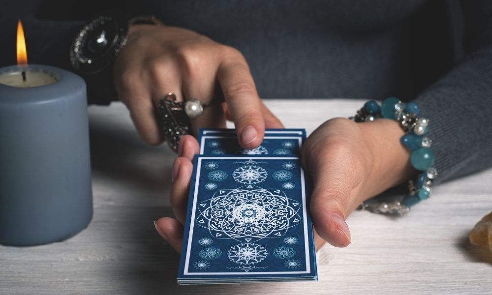 pessoa com cartas de tarot na mão