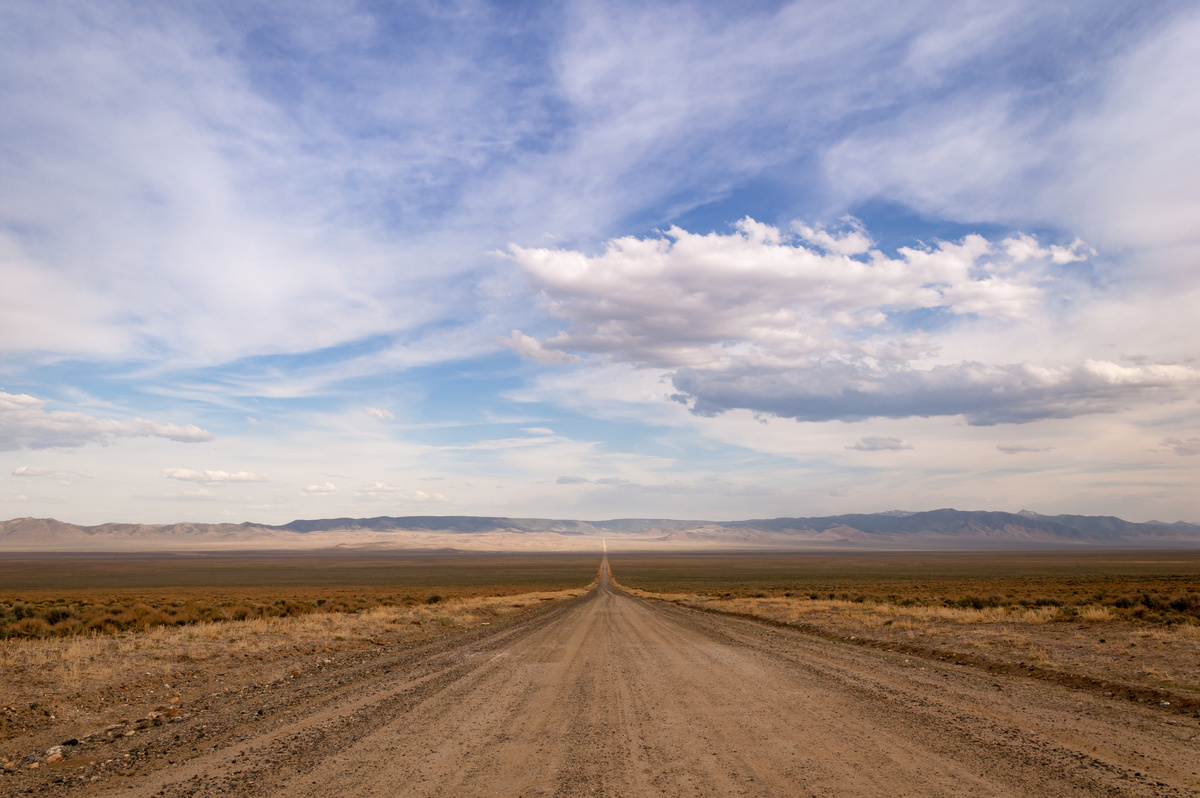 Horizonte visto em estrada de terra deserta.