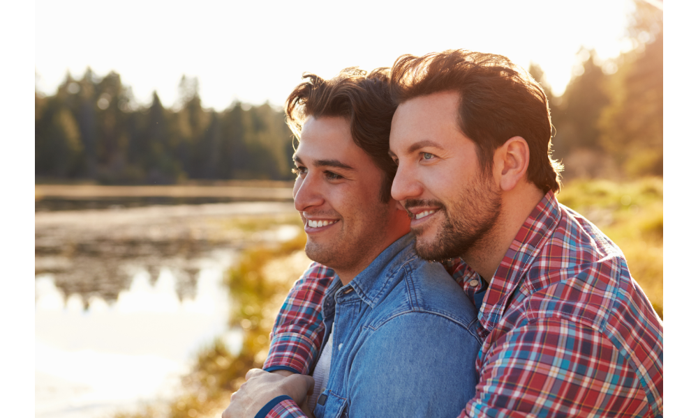 Casal de homens homossexuais olhando o horizonte.