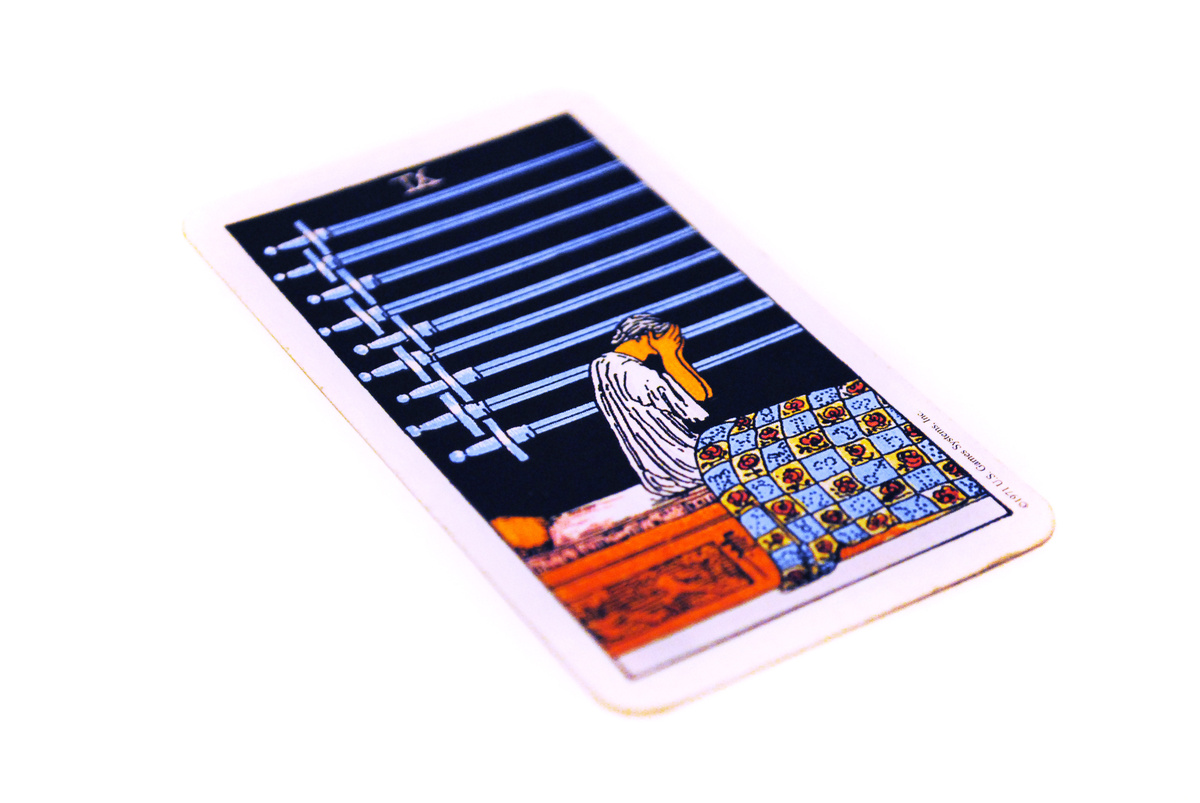 Carta 9 de espadas no tarot fundo branco.