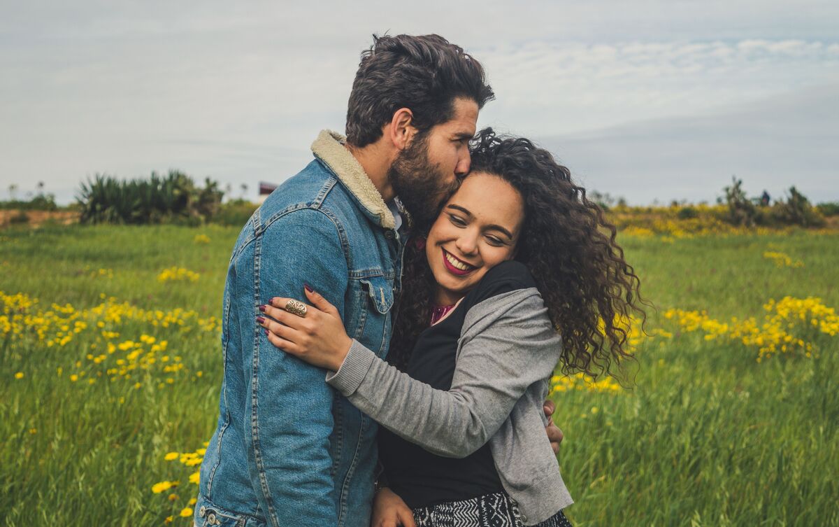 Casal de homem e mulher se abraçando.